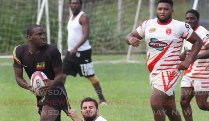 A Carib RC player, tackles a Rainbow RC player, in the Rugby International Sevens Tournament, at St. Mary's Grounds, St. Clair on Sunday. PHOTO:ANGELO M. MARCELLE -