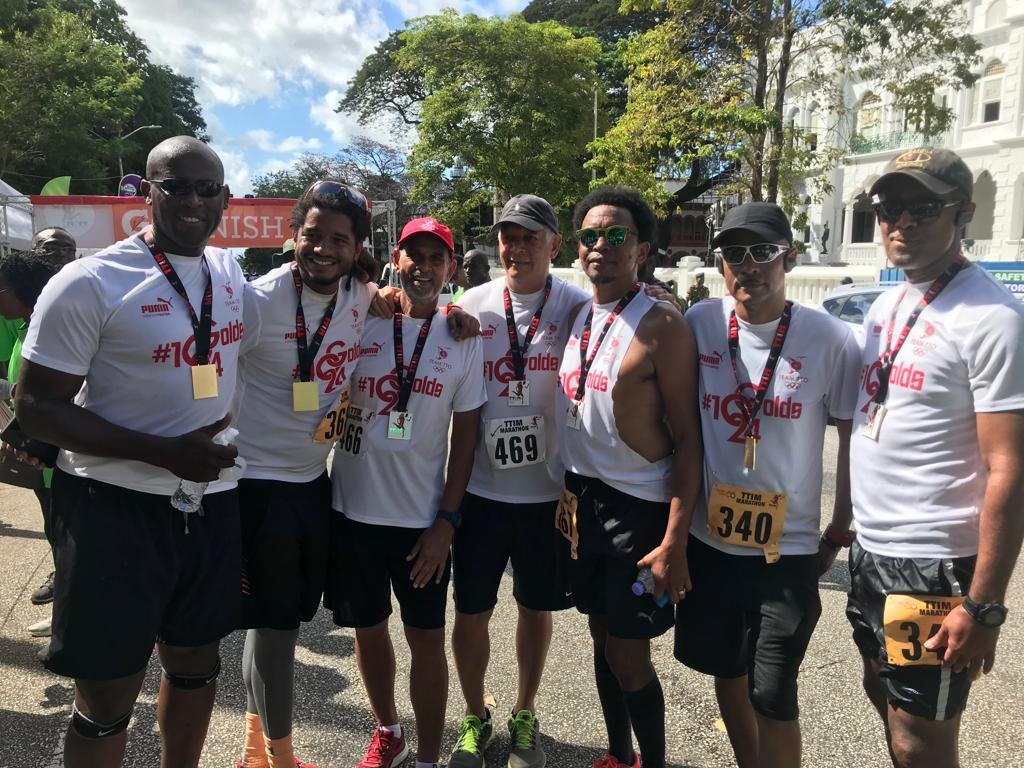 TTOC president Brian Lewis,centre, is flanked by Agriculture Minister Clarence Rambharat,left, and Mayor of Port of Spain Joel Martinez after they completed the TT International Marathon, on Sunday, at the Queen's Park Savannah.