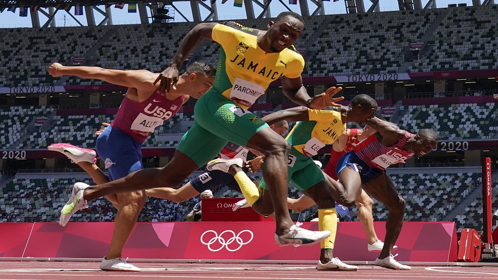 Hansle Parchment (left), of Jamaica, wins the men's 110m hurdles final ahead of Grant Holloway (right), of the United States, at the 2020 Summer Olympics, Thursday, Aug. 5, 2021, in Tokyo, Japan. Parchment's compatriot Ronald Levy (2nd right) finished third. (AP Photo/David J. Phillip)