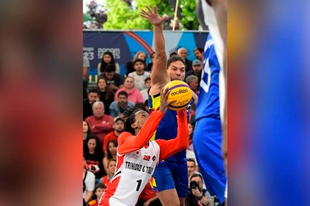 CLUTCH MOVE: TTO’s Ahkeel Boyd, left, goes up and under before sinking the shot that earned T&T its first medal at the Santiago 2023 Pan American Games, at the Estadio Español, yesterday. TTO pipped Venezuela 21-20 in the men’s basketball 3x3 bronze medal match. —Photo: Photosport/Panam Sports (Image obtained at trinidadexpress.com)